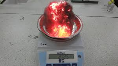 La llana de ferro sobre bàscula, la massa de la qual augmenta a temps real a mesura que la llana de ferro s’oxida.